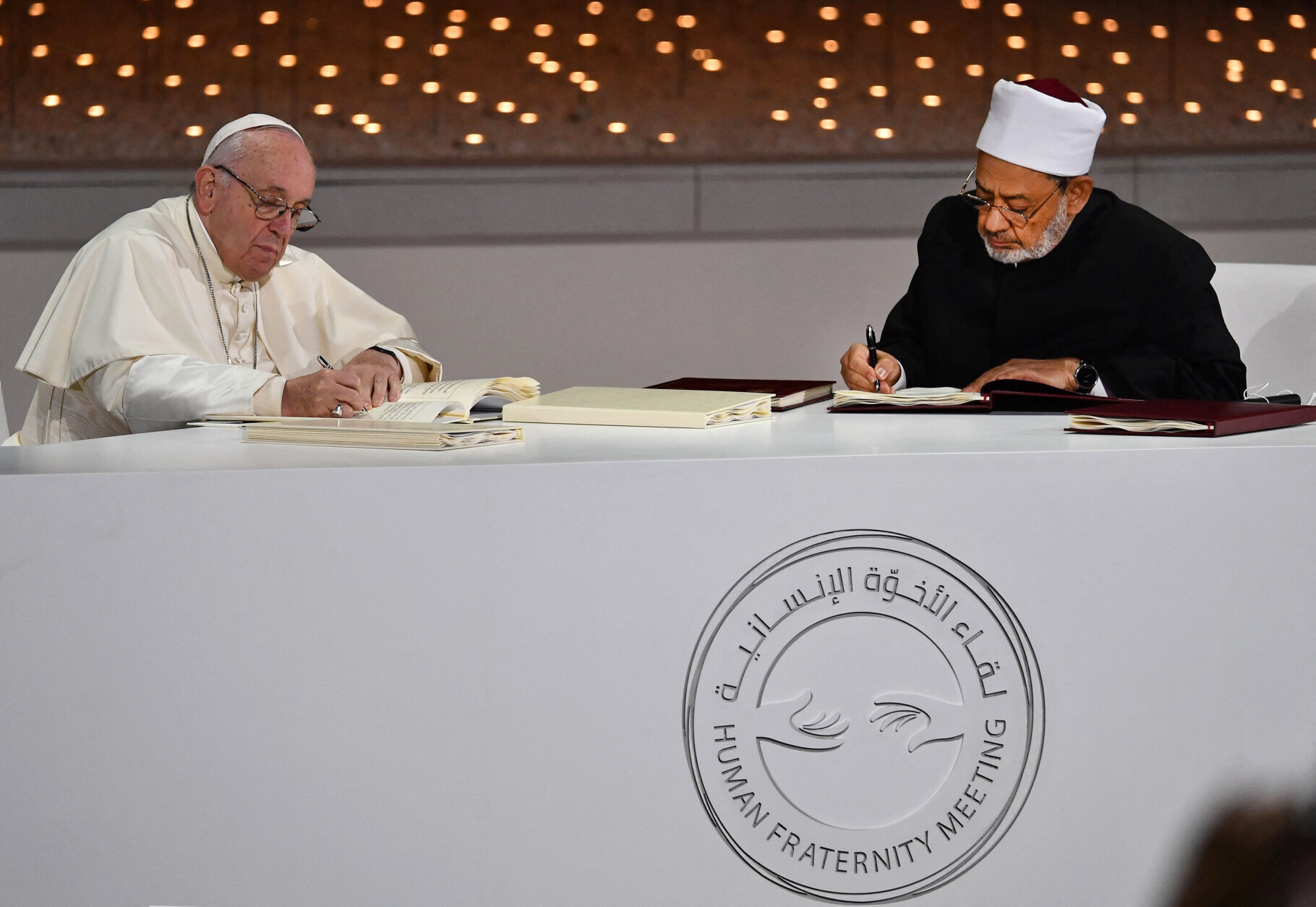 Pope Francis signs document pledging Christian-Muslim cooperation alongside Egypt's Azhar Grand Imam Sheikh Ahmed al-Tayeb.